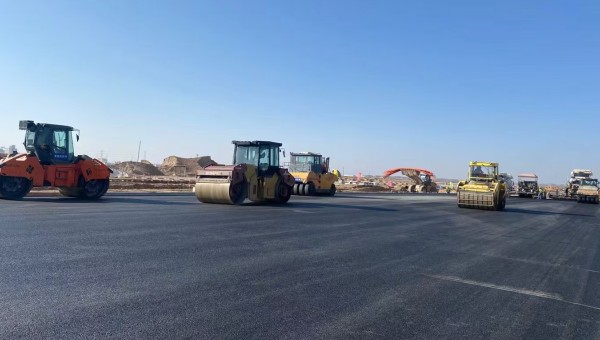 近日，在西部市政建設(shè)集團(tuán)蘭州新區(qū)城市礦產(chǎn)與表面處理產(chǎn)業(yè)園區(qū)（二期）周邊基礎(chǔ)設(shè)施項(xiàng)目—園區(qū)西路南延段（緯五十路至緯二十八路）項(xiàng)目現(xiàn)場(chǎng)，隨著一輛輛運(yùn)料車平穩(wěn)駛?cè)耄瑪備仚C(jī)將滾燙的瀝青混合料均勻鋪開，標(biāo)志著項(xiàng)